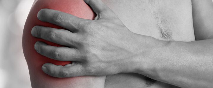 Eine Frau leidet unter Muskeldystrophie, einer Form der Myopathie, und hält sich daher die Schulter.